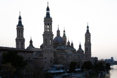 Zaragoza 'da günbatımı gökyüzüne karşı bazilika del pilar' ın çarpıcı silueti, Ebro nehrine yansıdı.