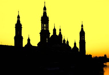 Zaragoza 'da günbatımı gökyüzüne karşı bazilika del pilar' ın çarpıcı silueti, Ebro nehrine yansıdı.