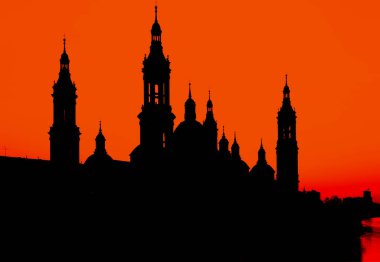 Zaragoza 'da günbatımı gökyüzüne karşı bazilika del pilar' ın çarpıcı silueti, Ebro nehrine yansıdı.