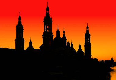Zaragoza 'da günbatımı gökyüzüne karşı bazilika del pilar' ın çarpıcı silueti, Ebro nehrine yansıdı.