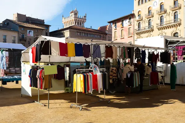 Açık mavi gökyüzünün altında, kurbanın resimli kasaba meydanında hareketli bir açık hava pazarı.