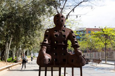 Güneşli bir günde çevresi yeşil ağaçlar ve çimlerle çevrili modern ofis binalarıyla dolu bir iş bölgesi.