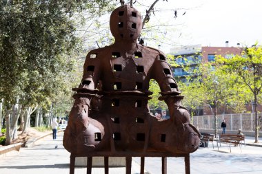 Güneşli bir günde çevresi yeşil ağaçlar ve çimlerle çevrili modern ofis binalarıyla dolu bir iş bölgesi.