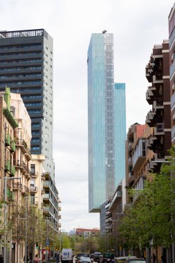 Güneşli bir günde çevresi yeşil ağaçlar ve çimlerle çevrili modern ofis binalarıyla dolu bir iş bölgesi.