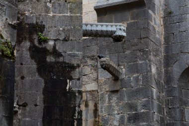 Avrupa 'daki taş bir binadan eski bir heykel uzanıyor.