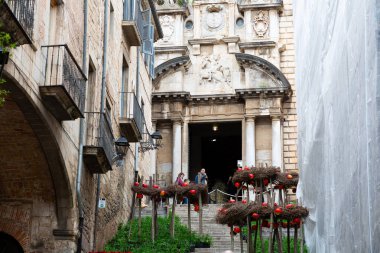 Girona 'nın eski kasabasında merdivenlerden çıkan turistler kemerli ve arka planda bir kilise var.