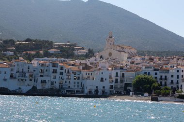 Güneşli bir yaz gününün tadını çıkaran turistler, İspanya 'nın başkenti Katalonya' da bulunan Costa Brava 'nın beyaz kadavra köyünün plajında güneşleniyorlar.