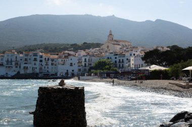 Güneşli bir yaz gününün tadını çıkaran turistler, İspanya 'nın başkenti Katalonya' da bulunan Costa Brava 'nın beyaz kadavra köyünün plajında güneşleniyorlar.
