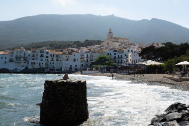 Güneşli bir yaz gününün tadını çıkaran turistler, İspanya 'nın başkenti Katalonya' da bulunan Costa Brava 'nın beyaz kadavra köyünün plajında güneşleniyorlar.
