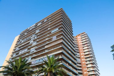 İspanya, Barselona 'da berrak mavi gökyüzüne karşı balkonları olan modern konut binalarının alçak açılı görüntüsü