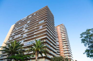 İspanya, Barselona 'da berrak mavi gökyüzüne karşı balkonları olan modern konut binalarının alçak açılı görüntüsü