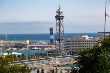 Barcelona cable car tower, hotel arts and world trade center dominating port vell harbor clipart