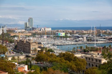 Barcelona cable car tower, hotel arts and world trade center dominating port vell harbor clipart