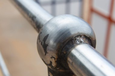 Paslanmış metal bir tırabzanın, pas ve hasarı gösteren görüntüsünü kapat.