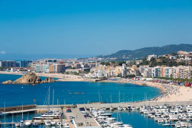 Limanı, plajı, palomera kayası, otelleri ve yazlık binaları olan beyaz şehir manzarası