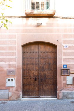 Yıpranmış kırmızı ahşap kapılı, grafiti etiketli, yaş ve çürüme belirtileri gösteren.