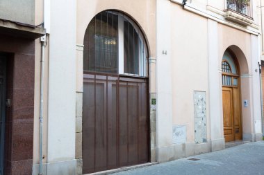 Yıpranmış kırmızı ahşap kapılı, grafiti etiketli, yaş ve çürüme belirtileri gösteren.