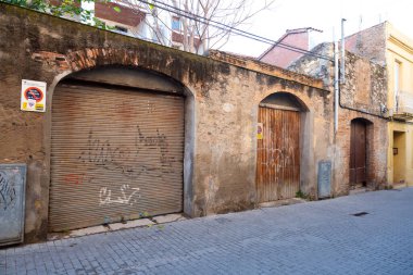 Yıpranmış kırmızı ahşap kapılı, grafiti etiketli, yaş ve çürüme belirtileri gösteren.
