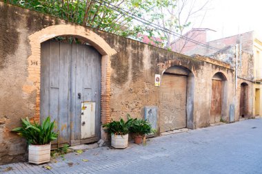 Yıpranmış kırmızı ahşap kapılı, grafiti etiketli, yaş ve çürüme belirtileri gösteren.