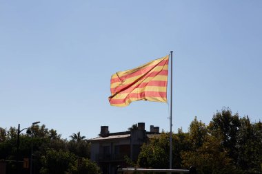 Senyera, katalan bayrağı, güneşli bir günde rüzgarda dalgalanan mavi gökyüzü