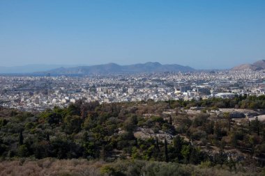 Atinalıların yerleşim bölgelerinin panoramik görüntüsü, uzak dağlara uzanan, parçalı bulutlu bir gökyüzünün altında