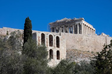 Turistler ve rehberler, restorasyon çalışmaları sırasında Atina 'nın akropolünde partenonu ziyaret ediyorlar.