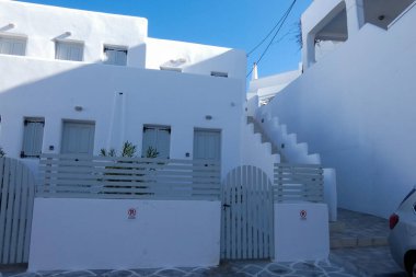 Mavi renkli saksılarda büyüyen küçük bitkiler beyaz bir duvarın basamaklarını süslüyor.