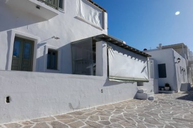 Yerel polis, Paros şehrinde dar bir kaldırım taşı caddesinde yürüyor.