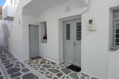 Yerel polis, Paros şehrinde dar bir kaldırım taşı caddesinde yürüyor.