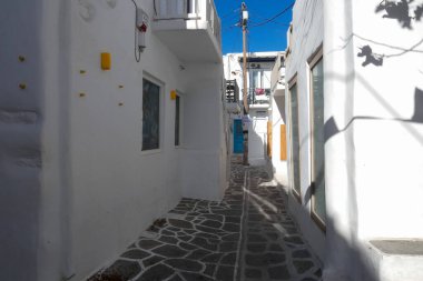 Yerel polis, Paros şehrinde dar bir kaldırım taşı caddesinde yürüyor.