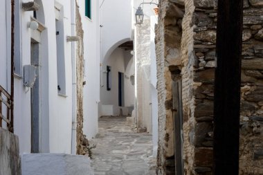 Yerel polis, Paros şehrinde dar bir kaldırım taşı caddesinde yürüyor.