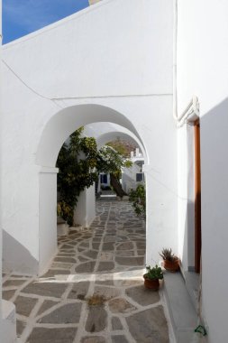 Yerel polis, Paros şehrinde dar bir kaldırım taşı caddesinde yürüyor.