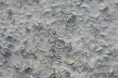 Çatlak toprak dokusu aşırı ısı ve yağmur eksikliğinden kaynaklanan soyut bir model oluşturuyor. Kuraklığı ve iklim değişikliğini simgeliyor.