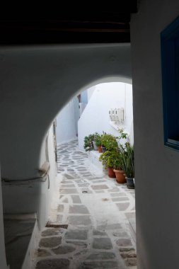 Beyaz boyanmış duvarları, taş kaldırımları olan dar bir tüneli ve Yunanistan 'daki Yunan adalarında büyüleyici bir Akdeniz atmosferi yaratan resimli bir ara sokak.
