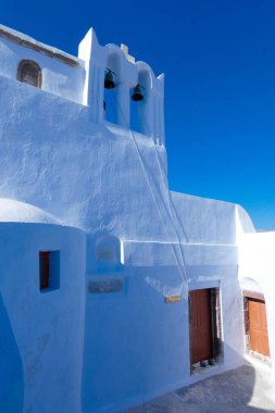 Santorini, Yunanistan 'da bayrak sallayan ve mavi kubbeli geleneksel Yunan Ortodoks Kilisesi
