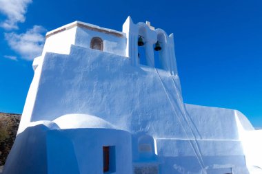 Santorini, Yunanistan 'da bayrak sallayan ve mavi kubbeli geleneksel Yunan Ortodoks Kilisesi