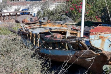 Eski, paslı ve çürüyen balıkçı teknesi karada terk edilmiş, ihmal ve bozulma belirtileri gösteriyor.