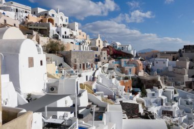 Beyaz boyanmış evler ve mavi kubbeli kiliseler Oia, Santorini, Yunanistan 'da pitoresk bir şehir manzarası yaratıyor.