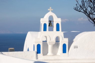 Santorini, Yunanistan 'da güneşli bir günde Ege Denizi' ne bakan mavi kubbeli beyaz kilise.