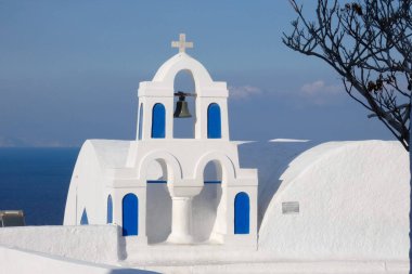 Santorini, Yunanistan 'da güneşli bir günde Ege Denizi' ne bakan mavi kubbeli beyaz kilise.