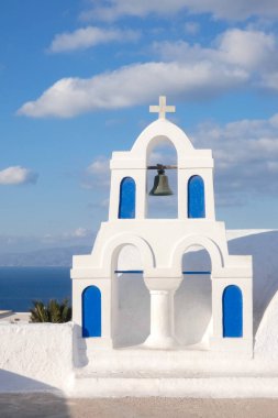 Santorini, Yunanistan 'da güneşli bir günde Ege Denizi' ne bakan mavi kubbeli beyaz kilise.