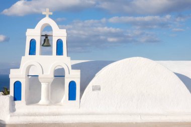 Santorini, Yunanistan 'da güneşli bir günde Ege Denizi' ne bakan mavi kubbeli beyaz kilise.