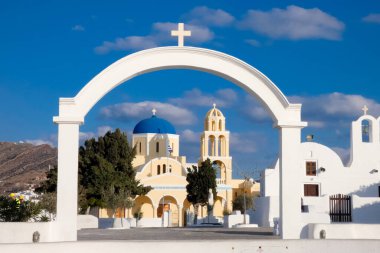 Beyaz boyanmış evler ve mavi kubbeli kiliseler Oia, Santorini, Yunanistan 'da pitoresk bir şehir manzarası yaratıyor.