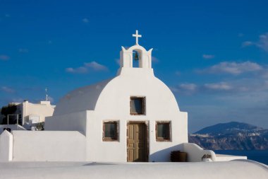 Beyaz boyanmış evler ve mavi kubbeli kiliseler Oia, Santorini, Yunanistan 'da pitoresk bir şehir manzarası yaratıyor.