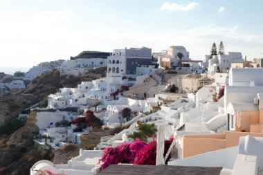 Beyaz boyanmış evler ve mavi kubbeli kiliseler Oia, Santorini, Yunanistan 'da pitoresk bir şehir manzarası yaratıyor.