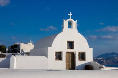 Beyaz boyanmış evler ve mavi kubbeli kiliseler Oia, Santorini, Yunanistan 'da pitoresk bir şehir manzarası yaratıyor.