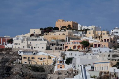 Geleneksel beyazlatılmış kilise ve kayalıklara tünemiş evler Santorini, Yunanistan 'daki Ege Denizi manzaralı bir manzara yaratır.