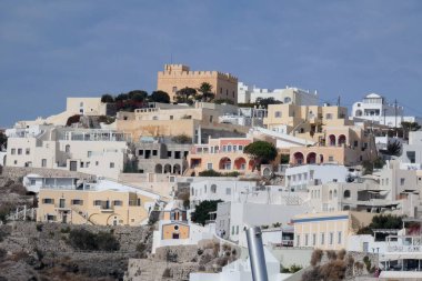 Geleneksel beyazlatılmış kilise ve kayalıklara tünemiş evler Santorini, Yunanistan 'daki Ege Denizi manzaralı bir manzara yaratır.