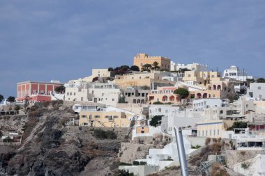 Geleneksel beyazlatılmış kilise ve kayalıklara tünemiş evler Santorini, Yunanistan 'daki Ege Denizi manzaralı bir manzara yaratır.