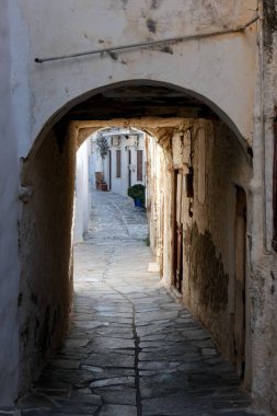 Beyaz boyanmış duvarları, taş kaldırımları olan dar bir tüneli ve Yunanistan 'daki Yunan adalarında büyüleyici bir Akdeniz atmosferi yaratan resimli bir ara sokak.